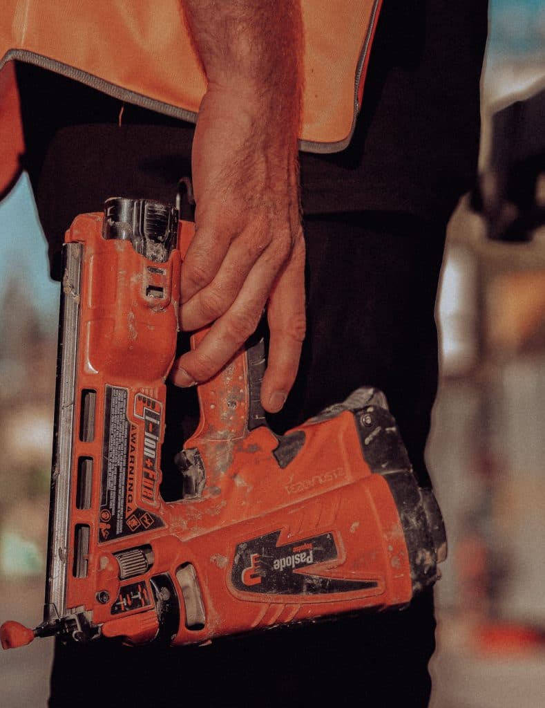 Carpenter using nail gun on commercial construction project